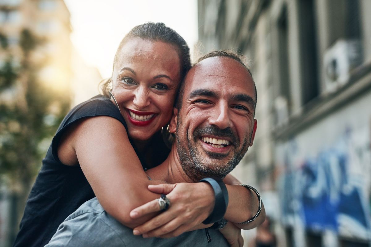 portrait mature couple piggyback city love vacation